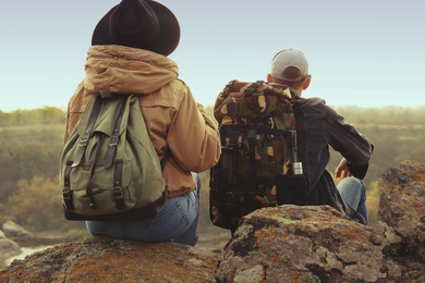 Group of friends with backpacks in autumn mountains, back view