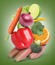 Stack of different vegetables and fruits on pale green background