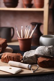 Clay and set of modeling tools on table in workshop