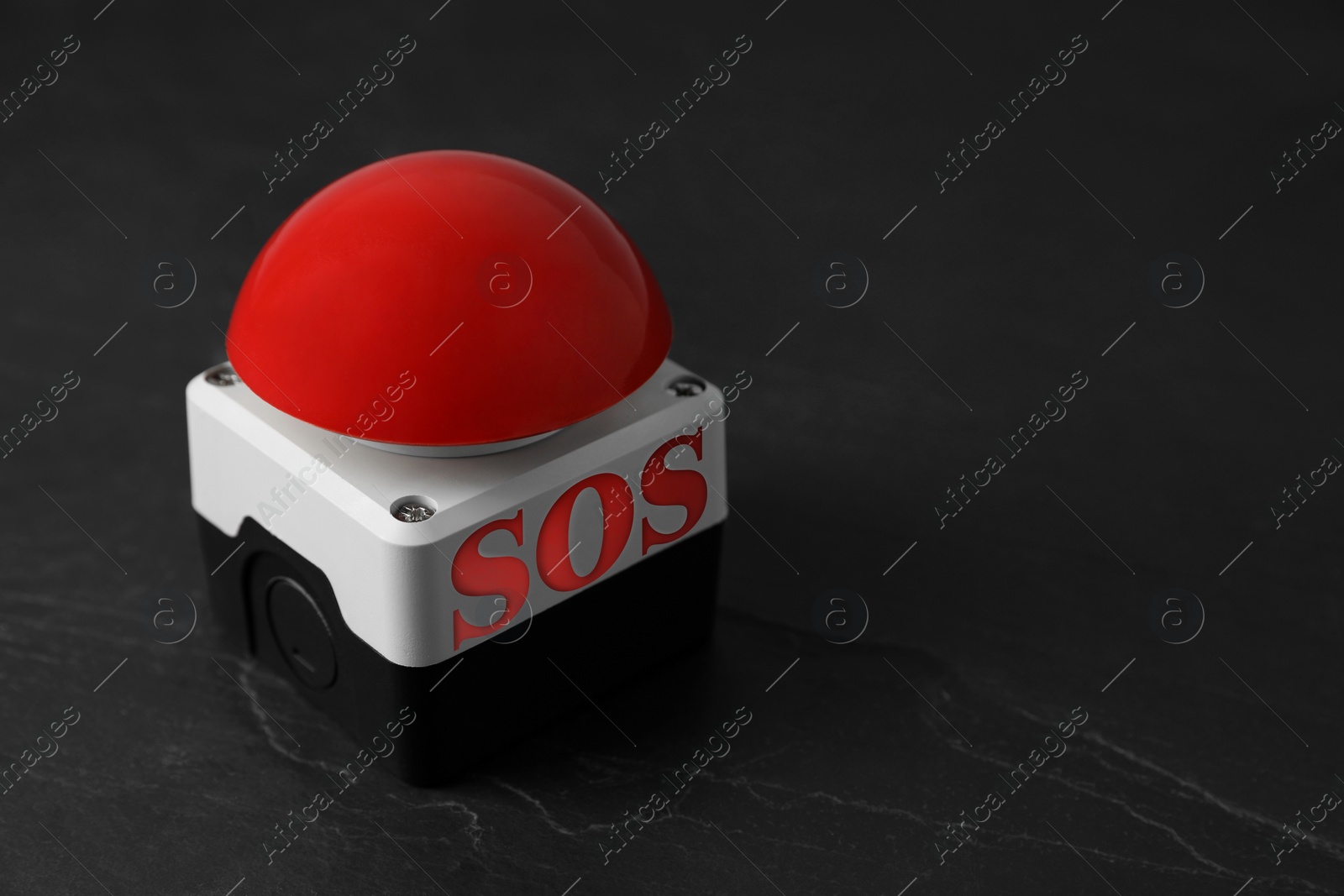 Image of Red SOS button on black table. Space for text