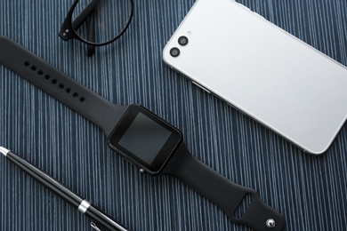 Photo of Flat lay composition with stylish smart watch on black table