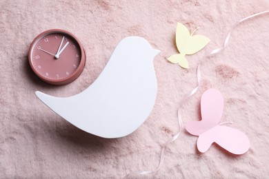 Photo of Flat lay composition with bird shaped child's night lamp on pink fabric