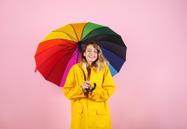 Photo of Woman with rainbow umbrella on color background