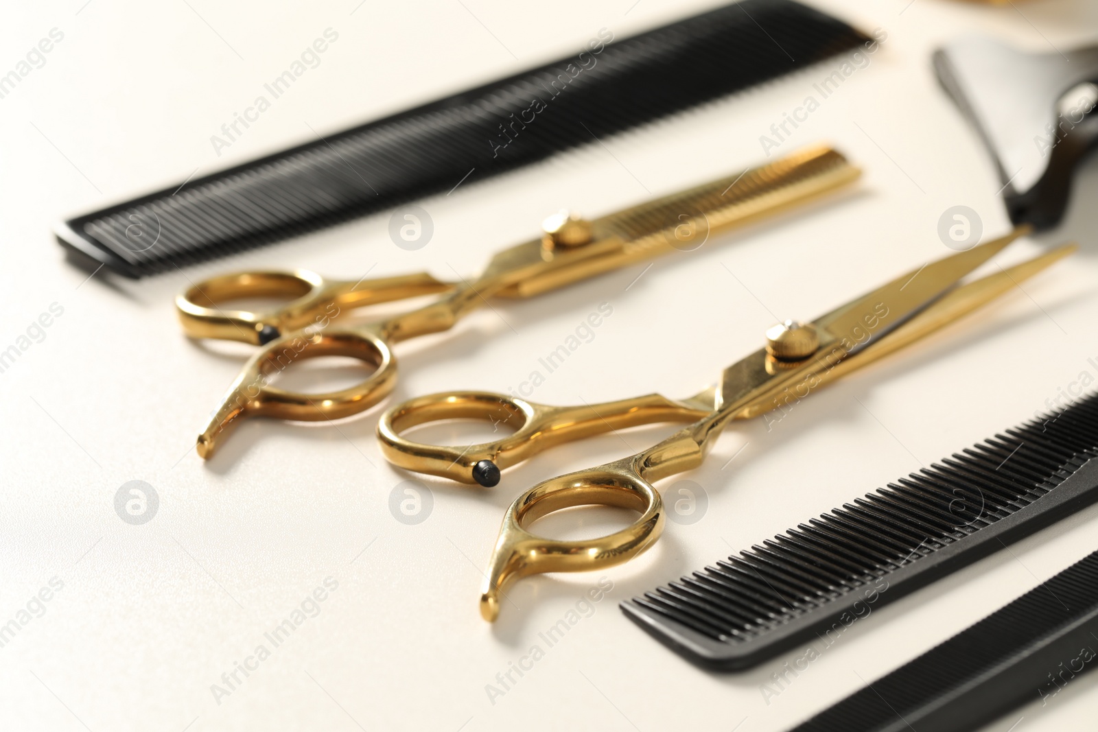 Photo of Hairdresser tools. Different scissors and combs on white table, closeup