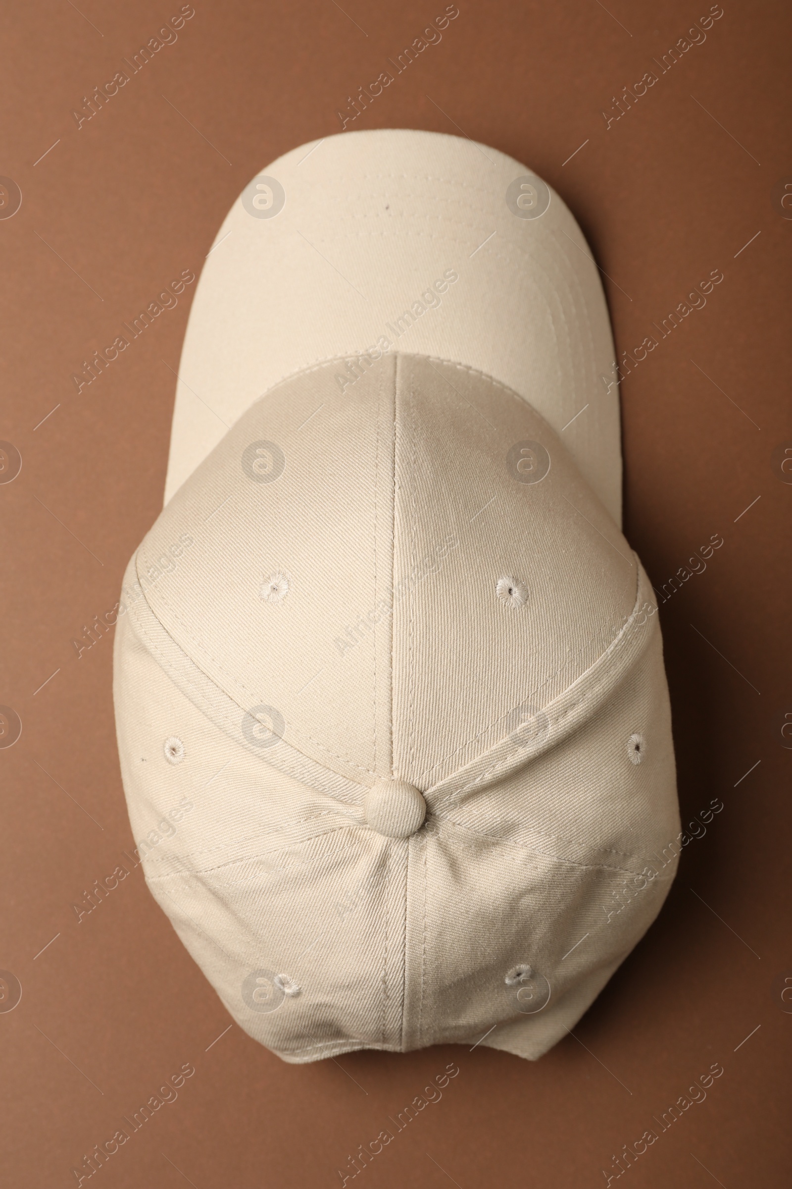 Photo of Baseball cap on brown background, top view. Mock up for design