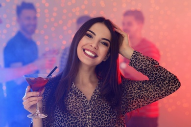Photo of Beautiful young woman with glass of martini cocktail in bar