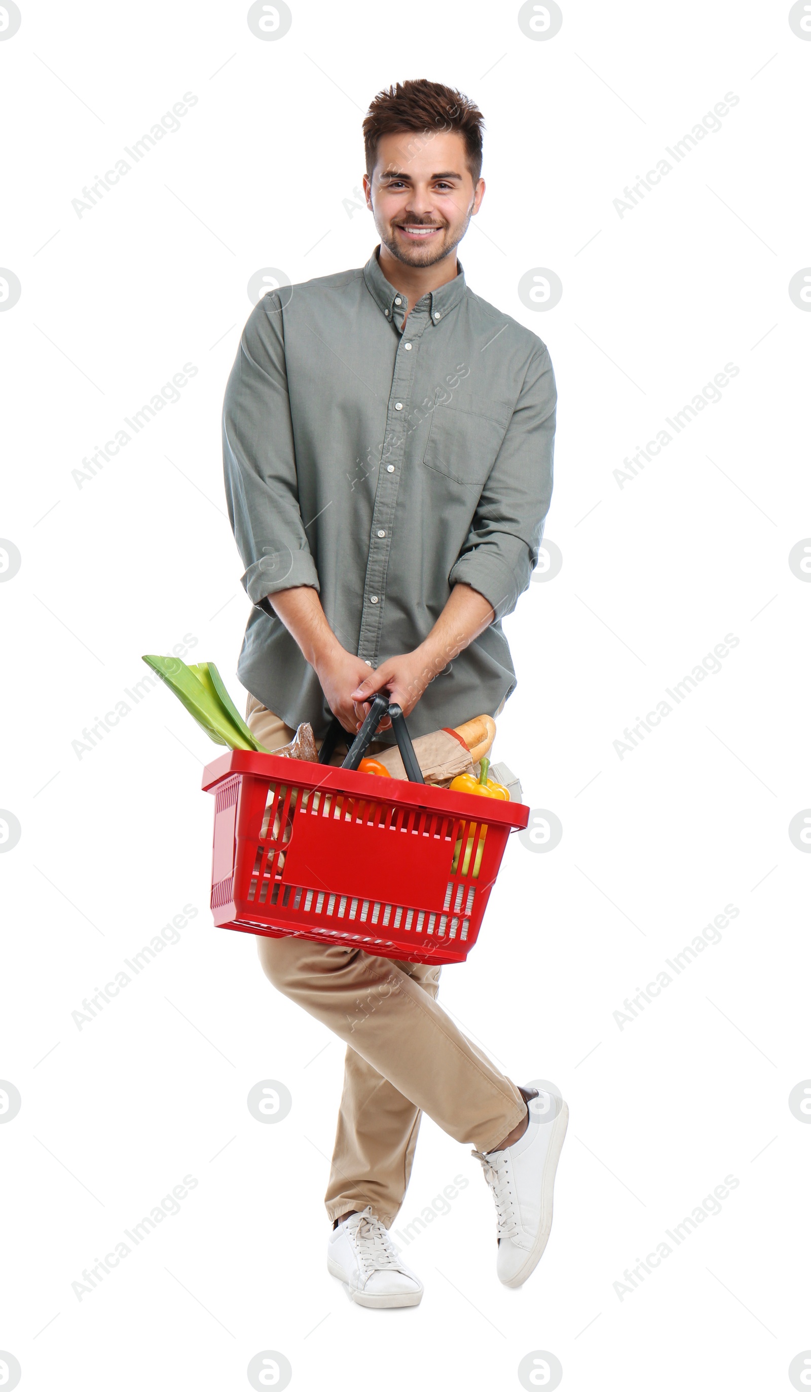 Photo of Young man with shopping basket full of products isolated on white