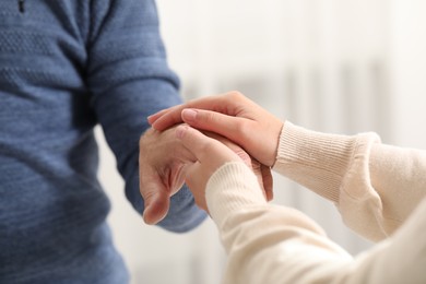 Photo of Trust and deal. Man with woman joining hands on blurred background, closeup
