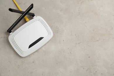 Photo of Modern Wi-Fi router on light background, top view. Space for text