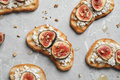 Photo of Bruschettas with cheese and figs on marble table, flat lay