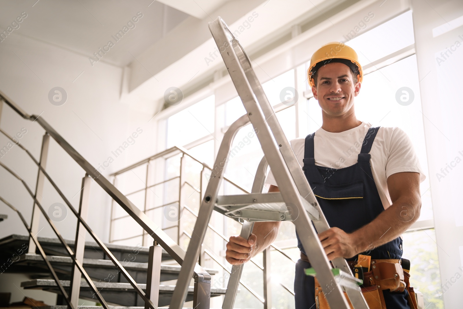 Photo of Professional builder with metal ladder on stairs