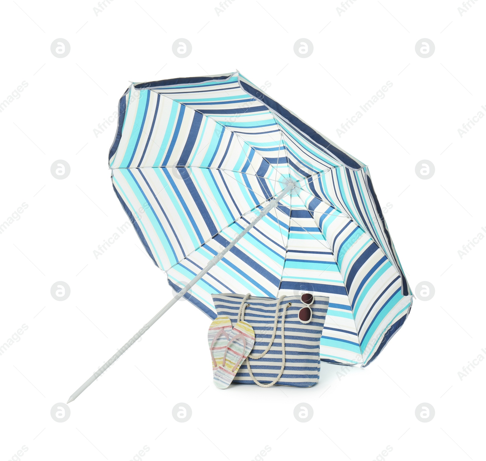 Photo of Open blue striped beach umbrella and accessories on white background