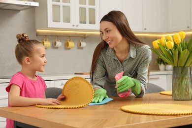 Photo of Spring cleaning. Mother and daughter tidying up kitchen together