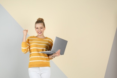 Photo of Portrait of emotional young woman with laptop on color background. Space for text