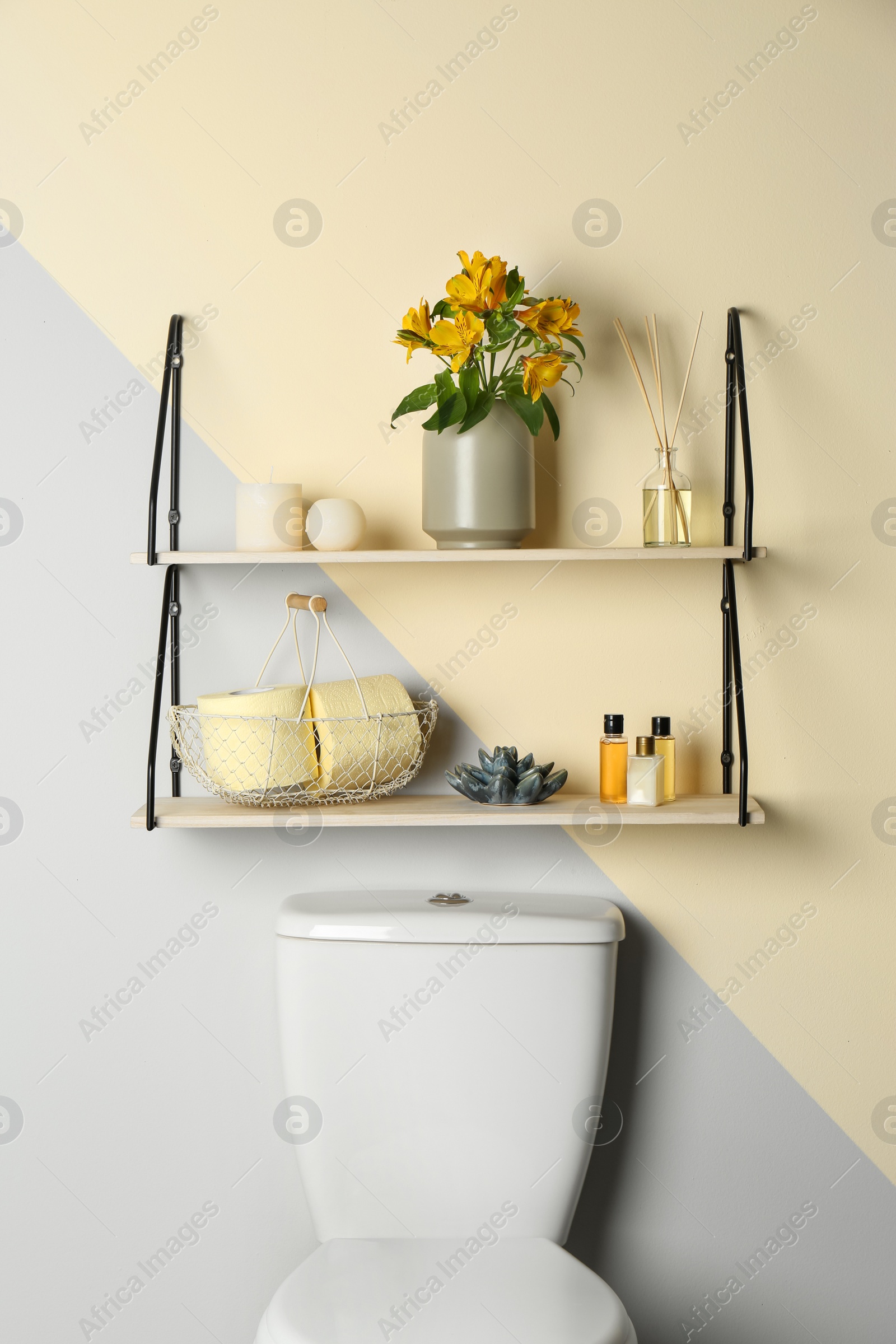 Photo of Shelves with different stuff on wall above toilet bowl in restroom interior