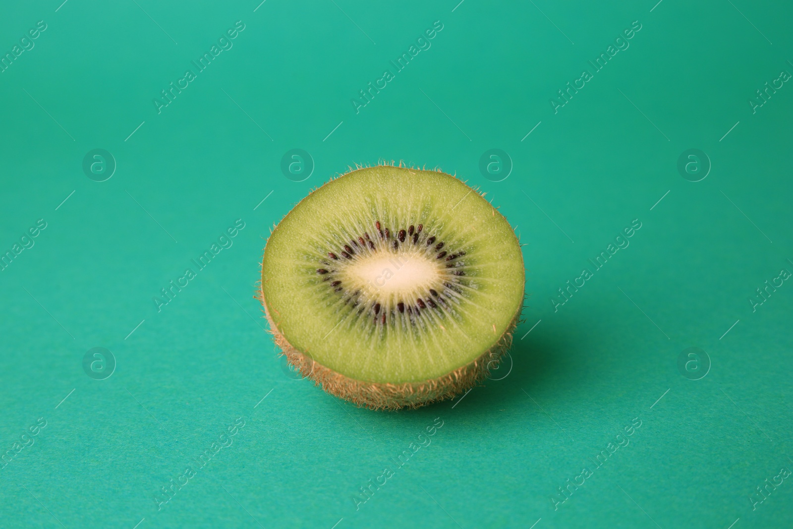 Photo of Cut fresh ripe kiwi on green background
