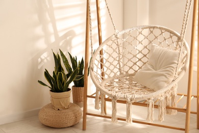 Photo of Comfortable hammock chair in stylish room. Home interior