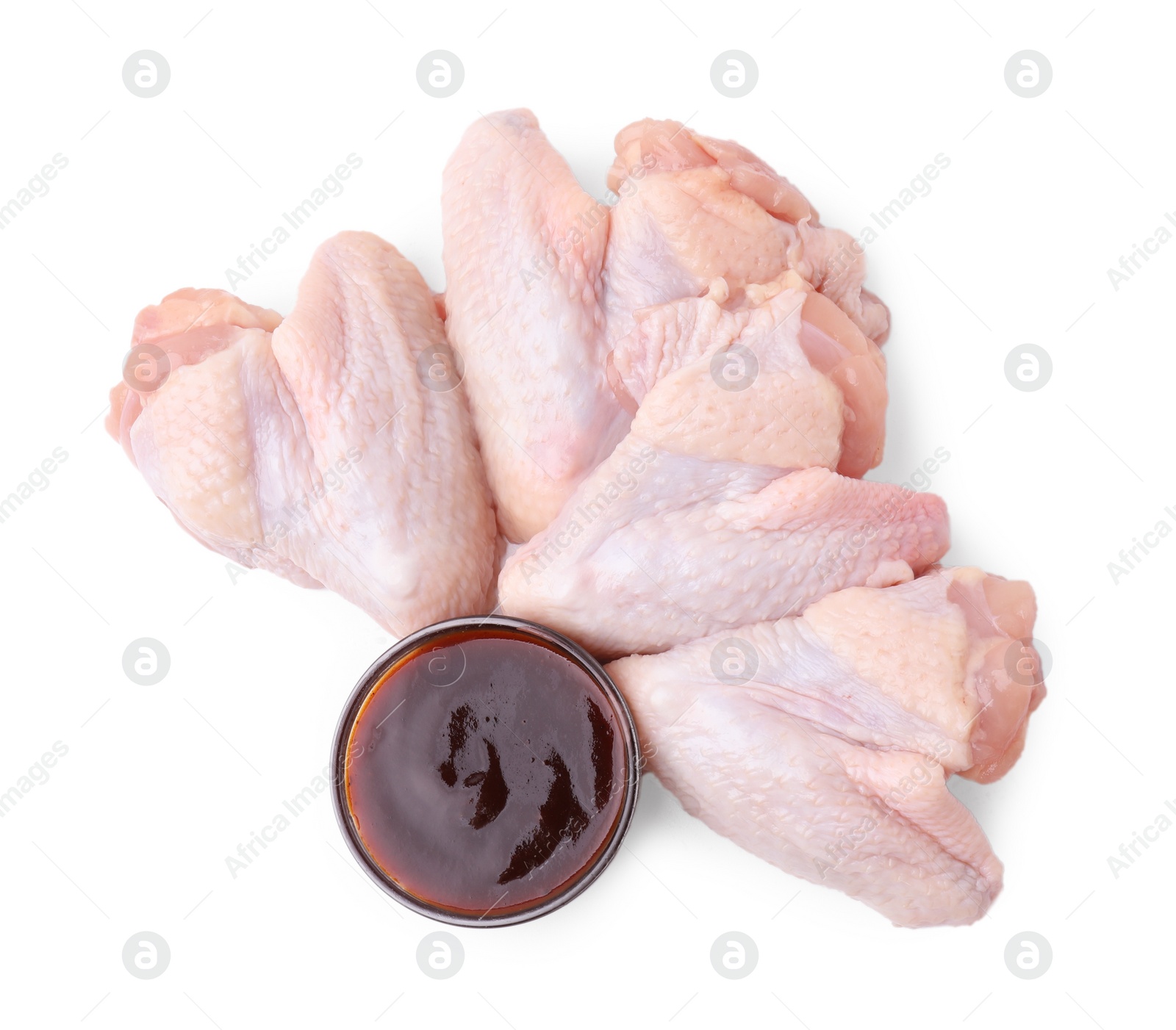 Photo of Fresh marinade and raw chicken wings isolated on white, top view