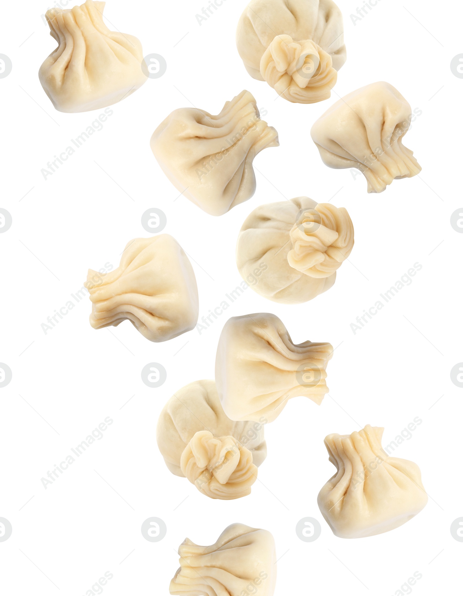 Image of Many tasty dumplings falling on white background