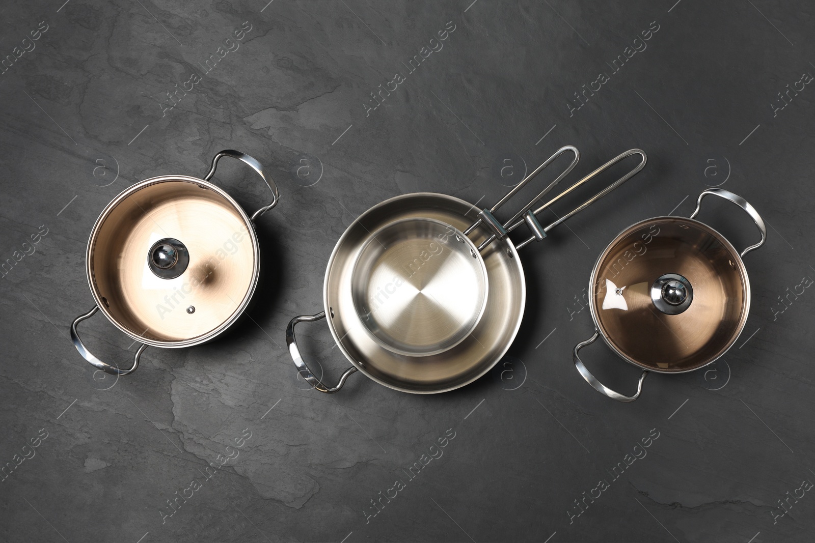 Photo of New cookware set on black table, flat lay