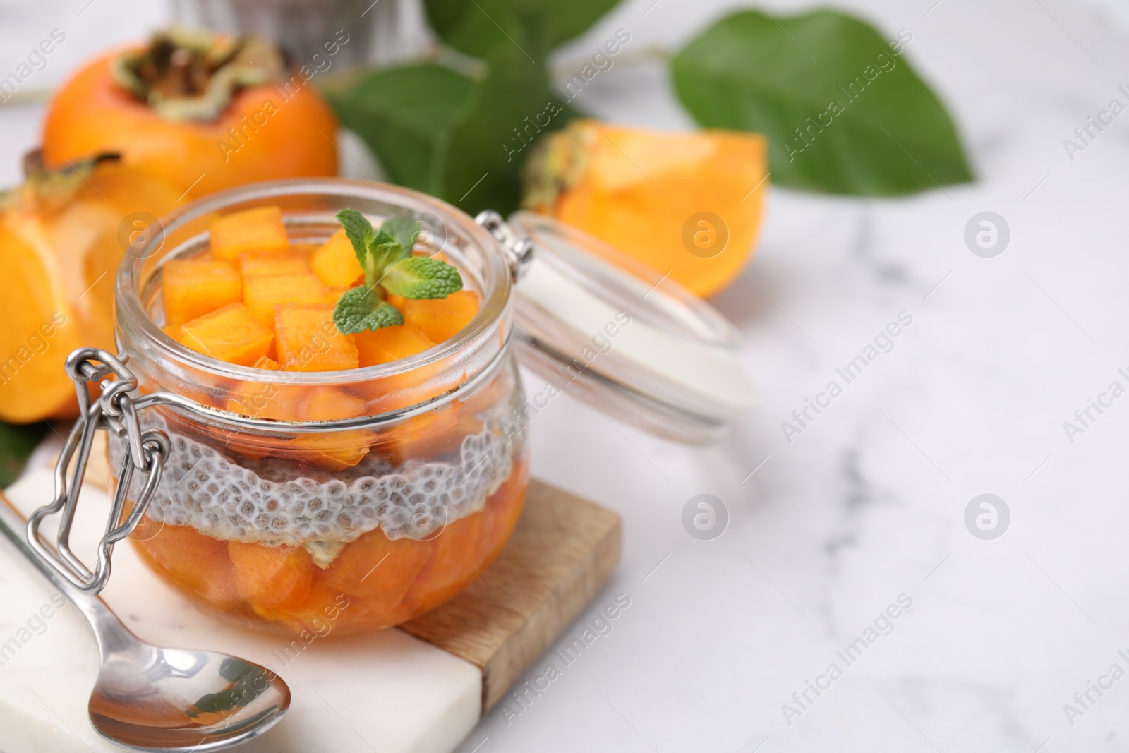 Photo of Delicious dessert with persimmon and chia seeds on table, closeup