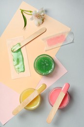 Photo of Flat lay composition with different types of wax and spatulas on color background