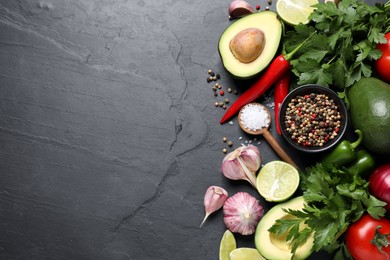 Photo of Fresh guacamole ingredients on black table, flat lay. Space for text