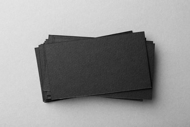 Photo of Blank black business cards on light background, top view. Mockup for design