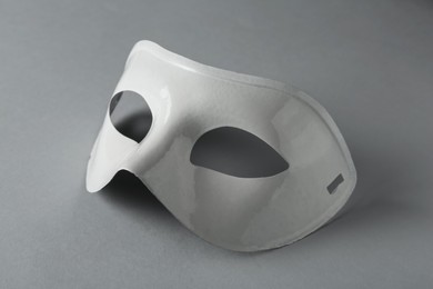 Photo of White theatre mask on grey background, closeup