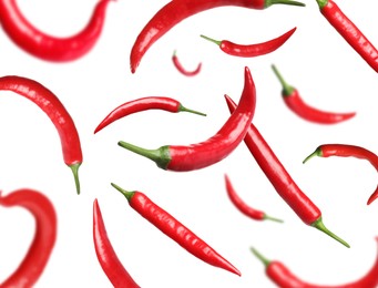Image of Ripe red chili peppers flying on white background