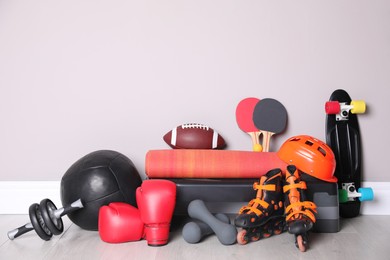 Different sports equipment near light wall indoors