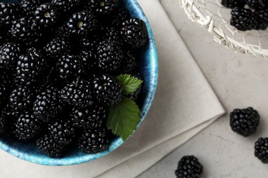 Photo of Tasty ripe blackberries and leaves on light table, flat lay