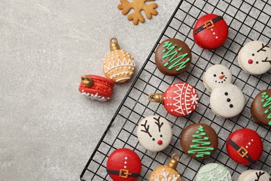 Photo of Beautifully decorated Christmas macarons on light grey table, flat lay