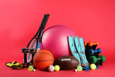 Set of different sports equipment on red background