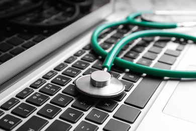 Photo of Stethoscope on laptop, closeup. Concept of technical support