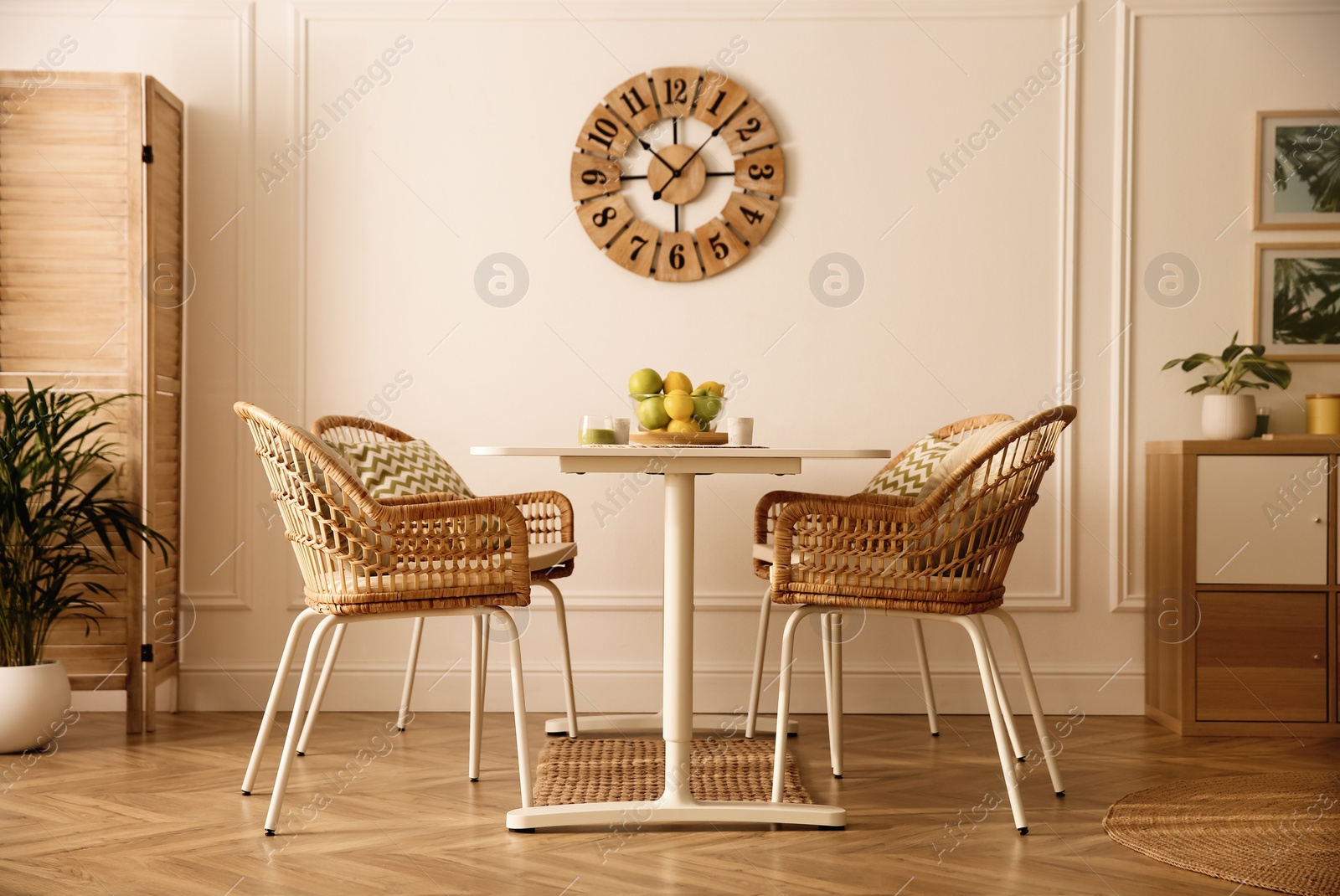 Photo of Stylish white dining table and wicker chairs in room. Interior design