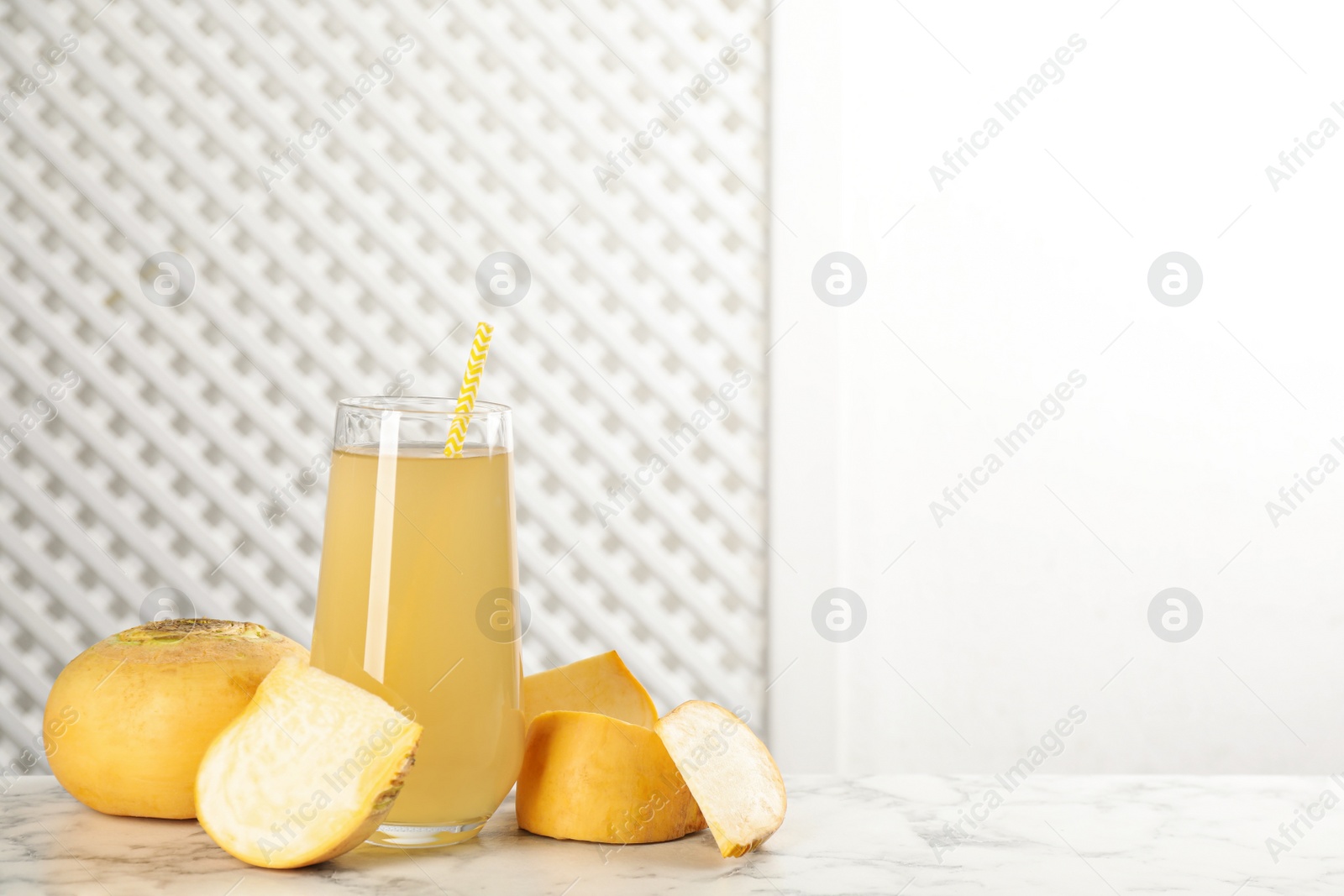 Photo of Freshly made turnip juice on white marble table, space for text