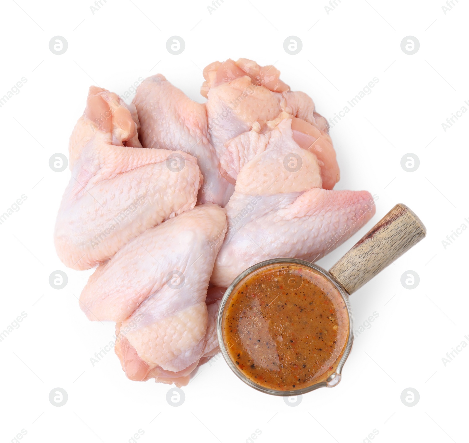 Photo of Fresh marinade and raw chicken wings isolated on white, top view