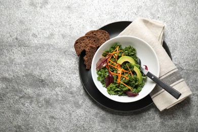 Photo of Tasty fresh kale salad on grey table, top view. Space for text