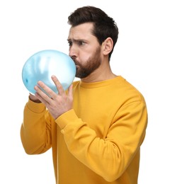 Man inflating light blue balloon on white background