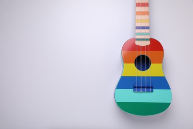 Photo of Colorful ukulele on white background, top view and space for text. String musical instrument