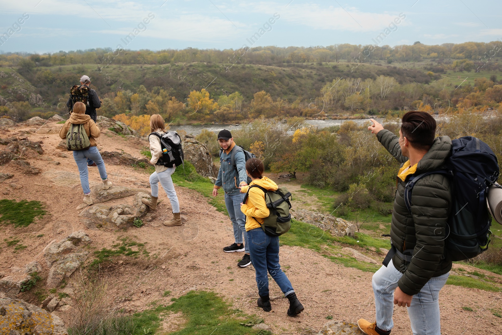 Photo of Group of hikers with backpacks climbing up mountains