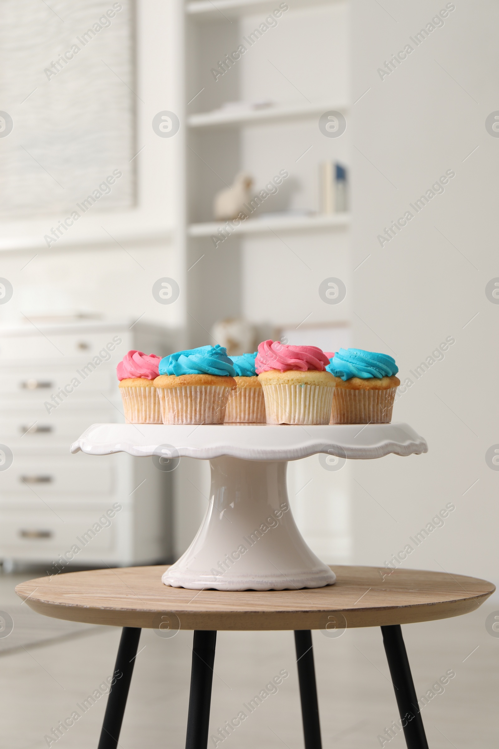 Photo of Delicious cupcakes with bright cream on wooden table indoors