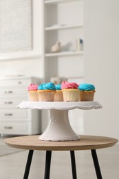 Delicious cupcakes with bright cream on wooden table indoors