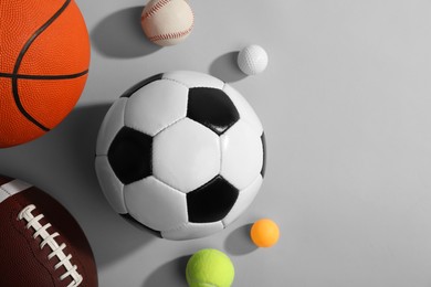 Photo of Many different sports balls on gray background, flat lay. Space for text