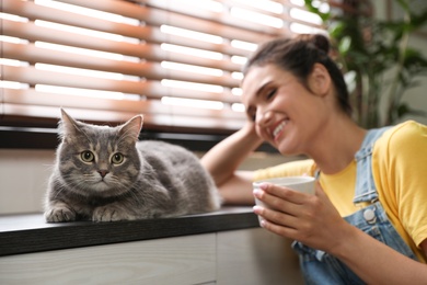 Photo of Young woman with cute cat at home. Pet and owner