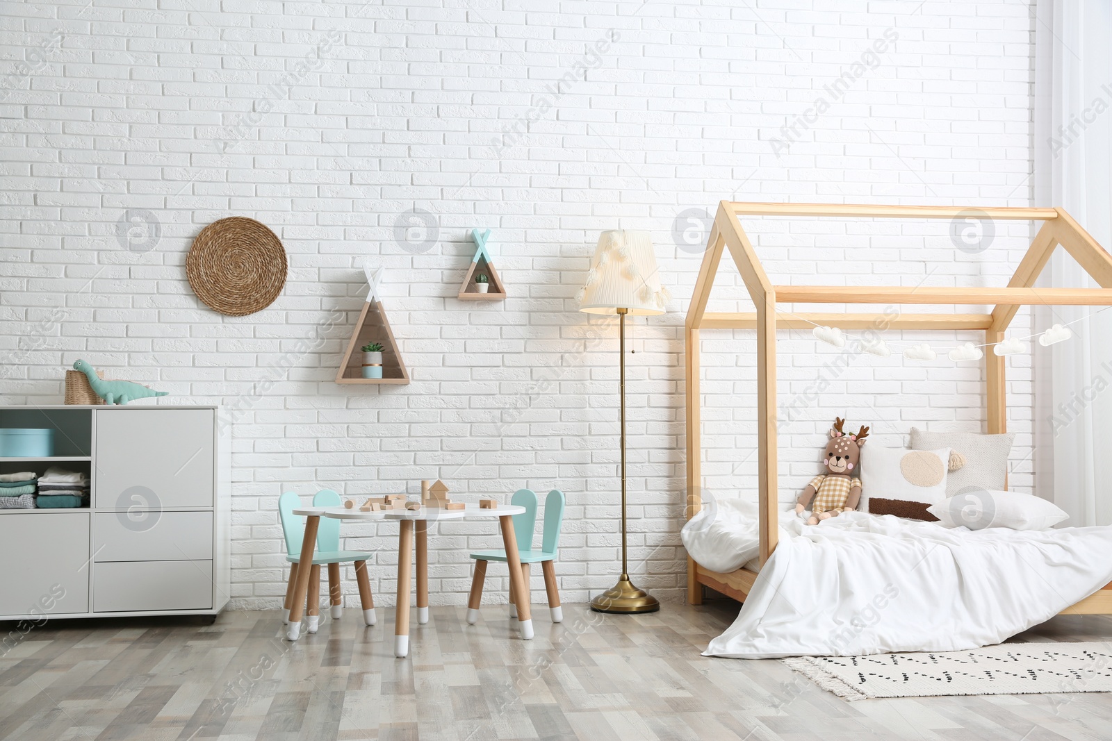 Photo of Cute children's room interior with bed and little table