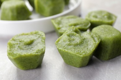 Photo of Frozen broccoli puree cubes on table, closeup