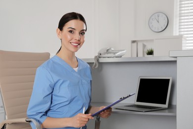 Photo of Receptionist with clipboard at workplace in hospital