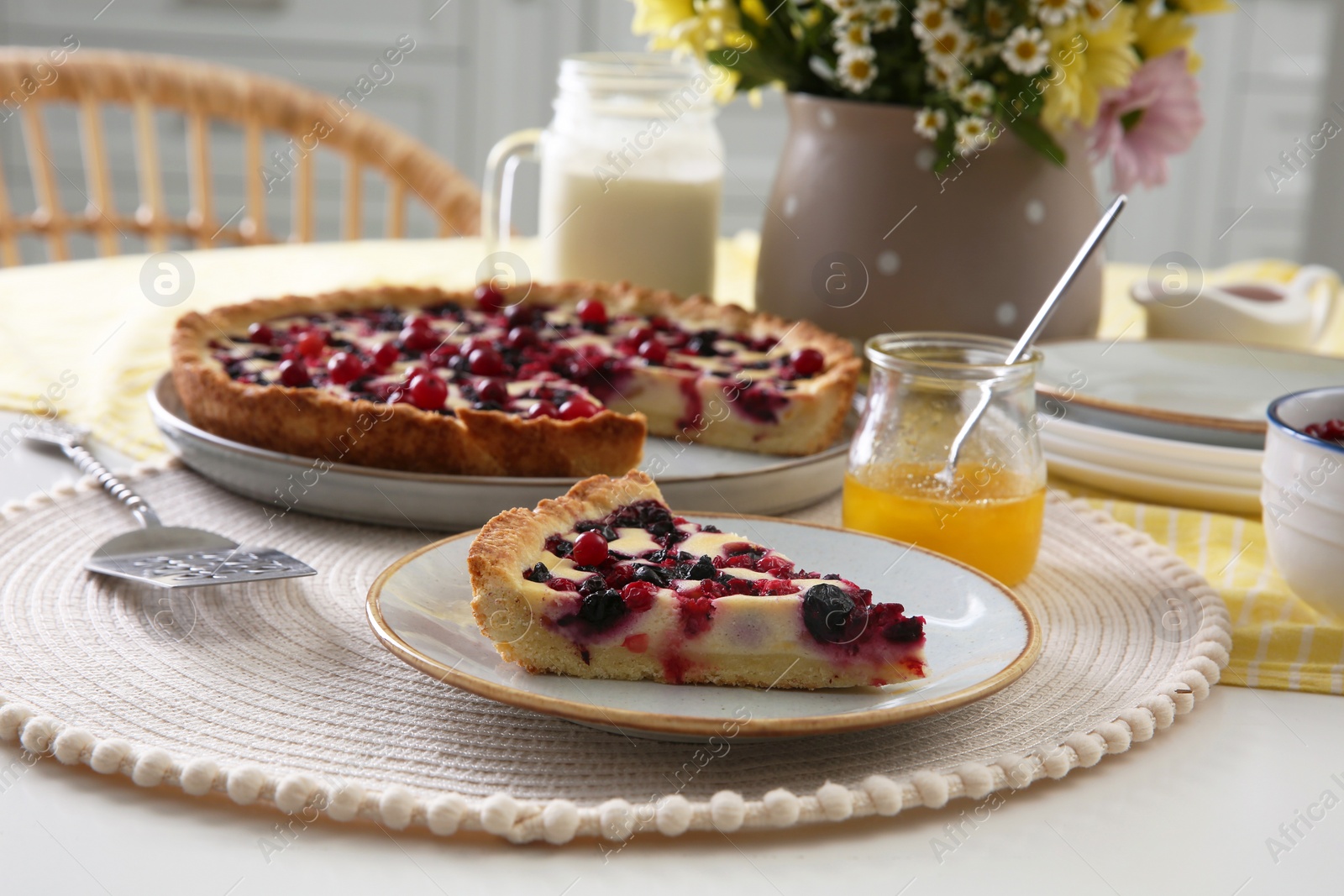 Photo of Piece of delicious currant pie on white table indoors